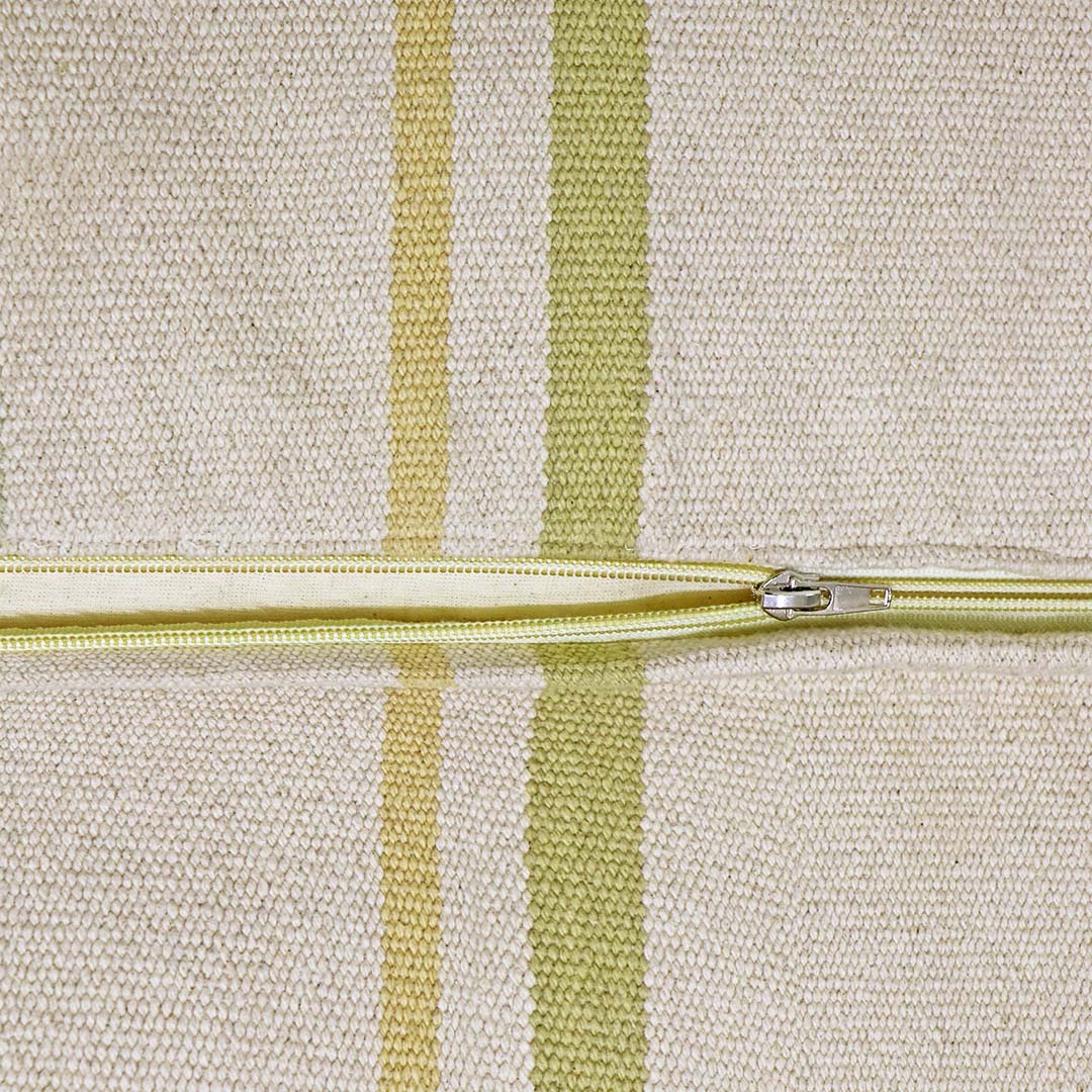 Detail van de gestreepte stof van de poef met een open rits.
