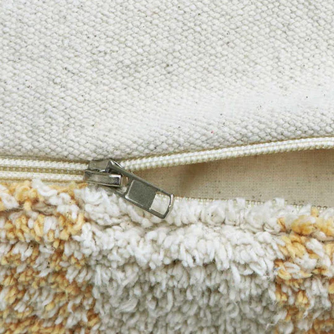 Detail van de rits op de Lorena Canals poef met honingkleurig geruit patroon.
