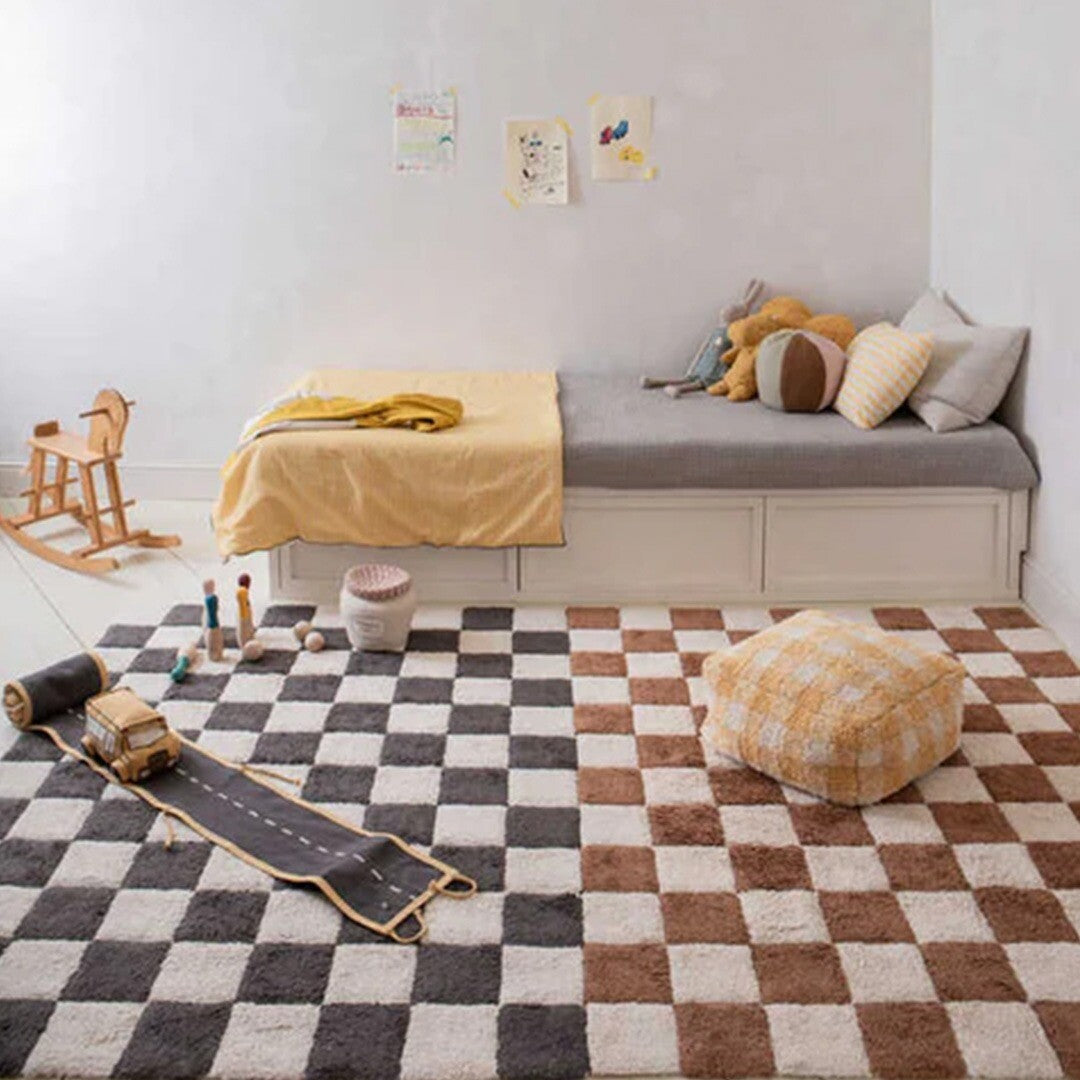 Twee Lorena Canals vloerkleden met geruite patronen, bruin/wit en grijs/wit, in een kinderkamer.