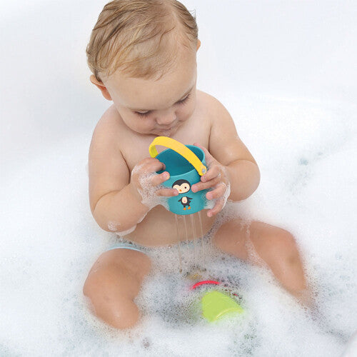 Een baby speelt in bad met een blauw Ludi badspeelgoed stapelemmertje met pinguïnfiguur.