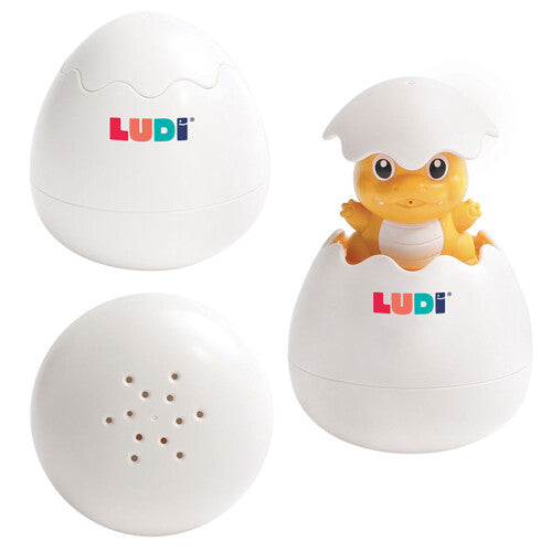 Drie weergaven van het Ludi badspeeltje dino ei: gesloten, open met dino, en de onderkant met spuitgaatjes.