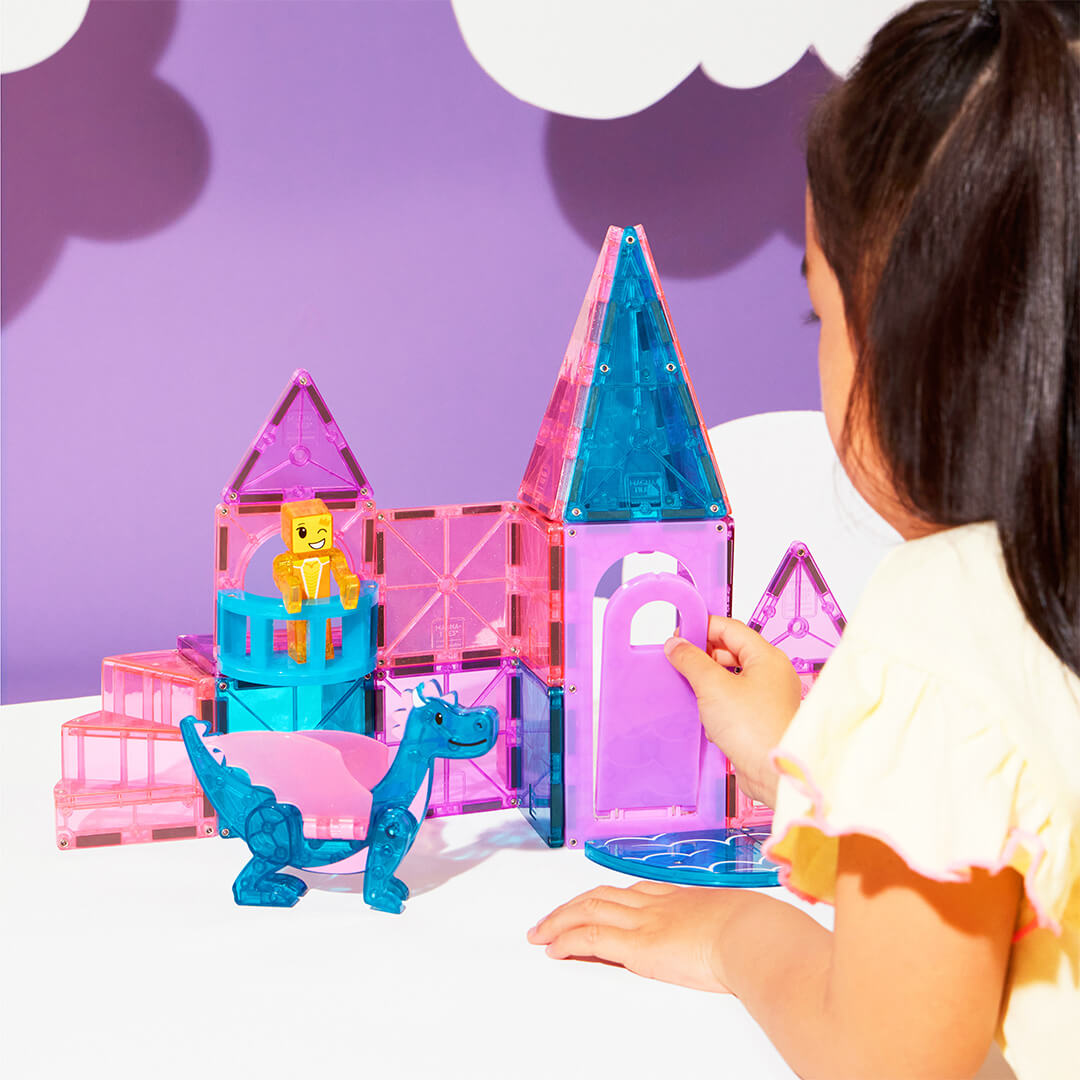 Een kind speelt met de Magna-Tiles Castle bouwset en opent een poort van het kasteel.