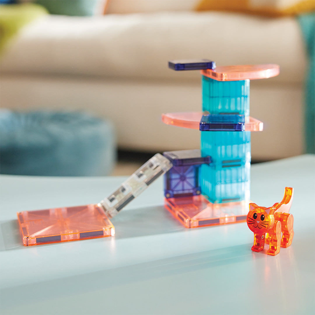 De Magna-Tiles Cat Tree bouwset met kattenboom en kattenfiguur op een tafel in een woonkamer.