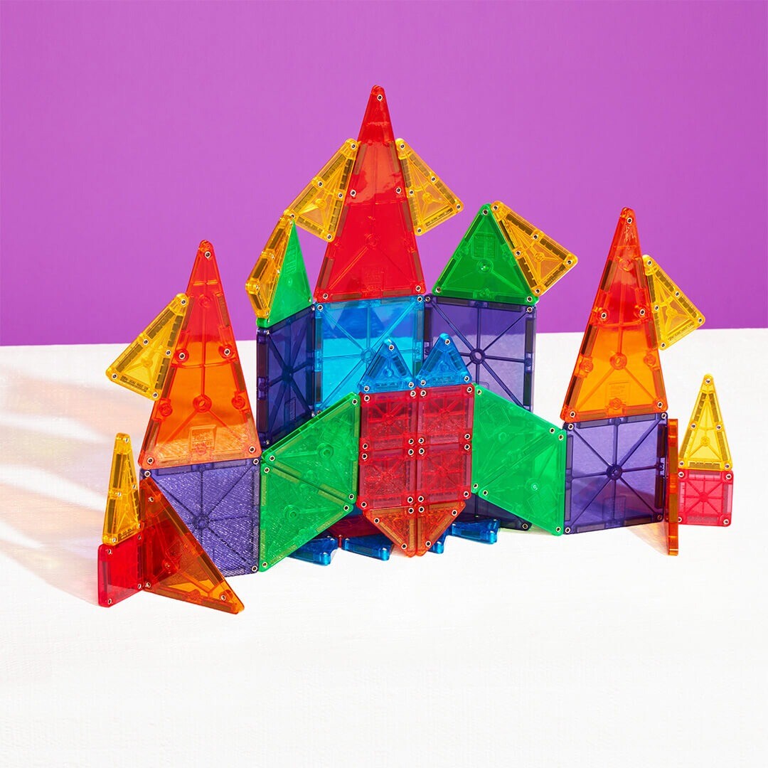 Een kleurrijk gebouw, lijkend op een kasteel, gemaakt van Magna-Tiles magnetische tegels.