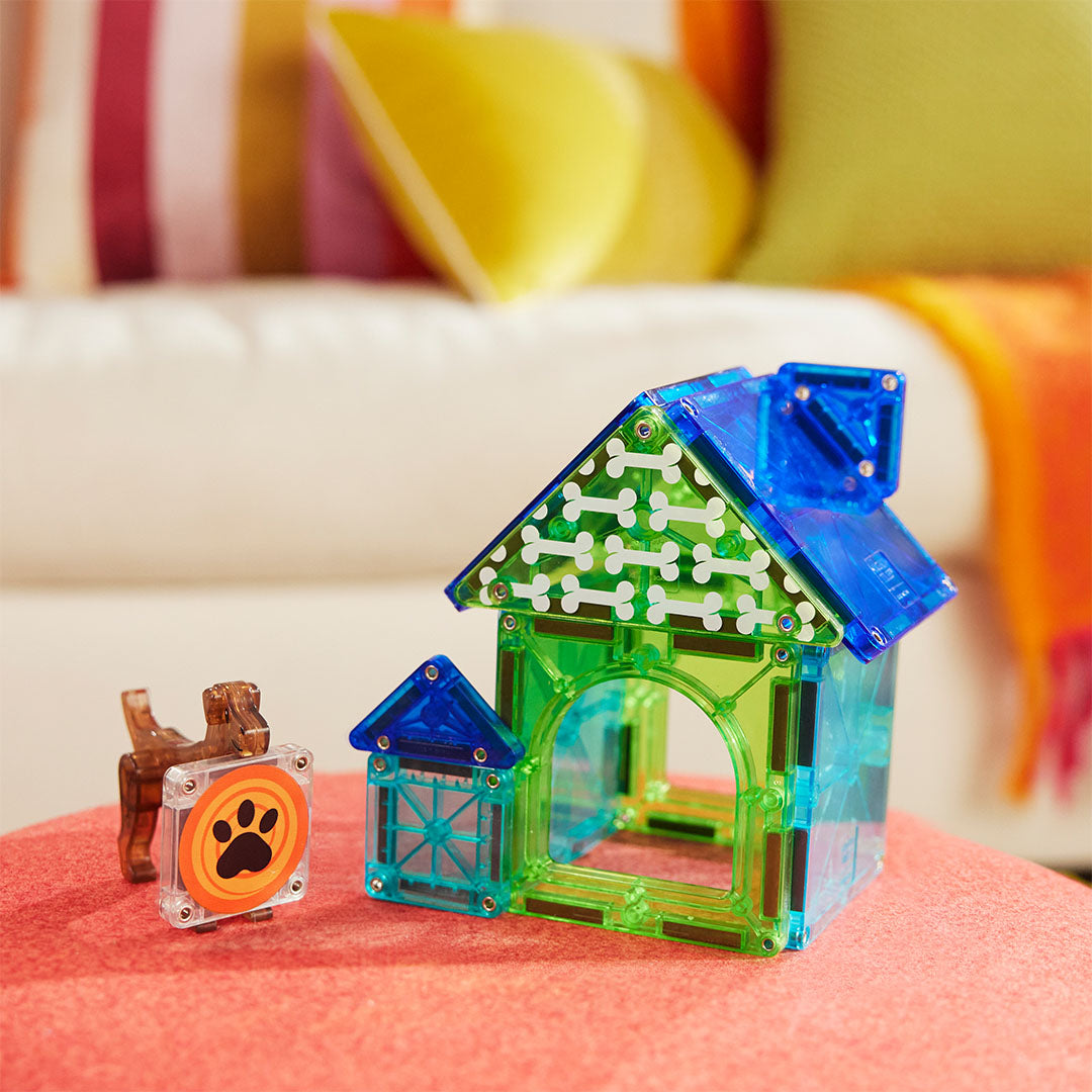 De Magna-Tiles magnetische tegels Dog House bouwset met een hondenhok, een hond en een tegel met pootafdruk op een rode ondergrond.