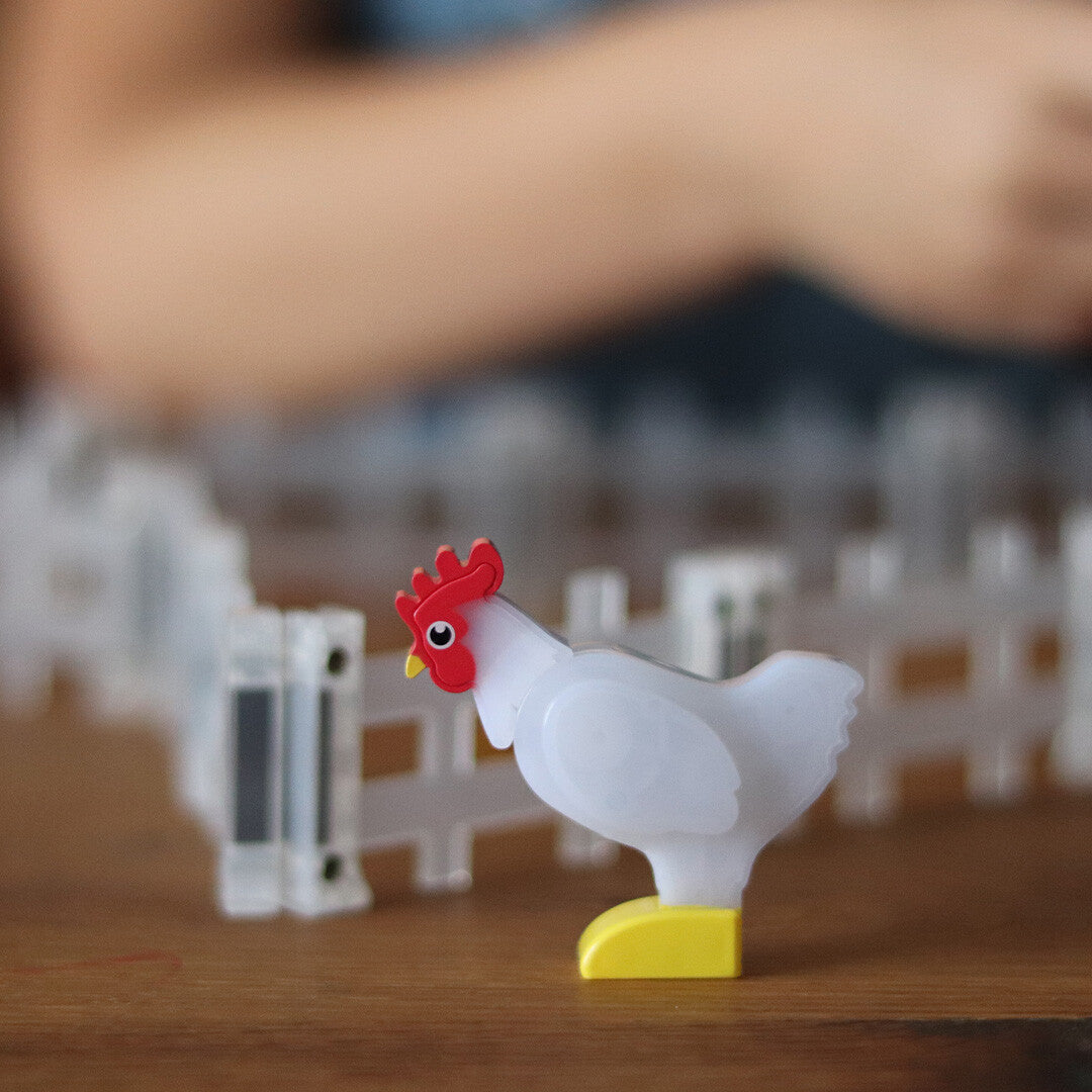 Detail van een witte kipfiguur met rode kam en gele poten van de Magna-Tiles Farm Animals bouwset.