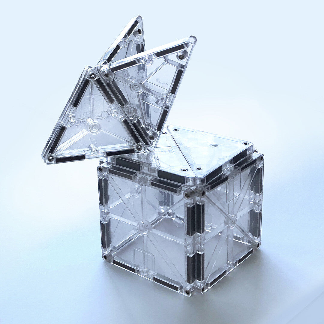Een kubus met een openklappend deksel, gebouwd van transparante Magna-Tiles magnetische tegels.
