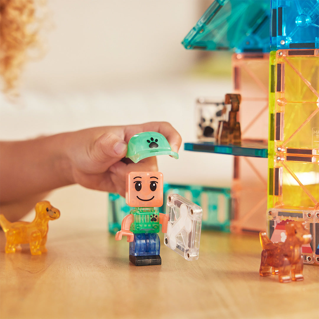 Detail van een kinderhand die een pet opzet bij het kindfiguur van de Magna-Tiles Puppy Park bouwset.
