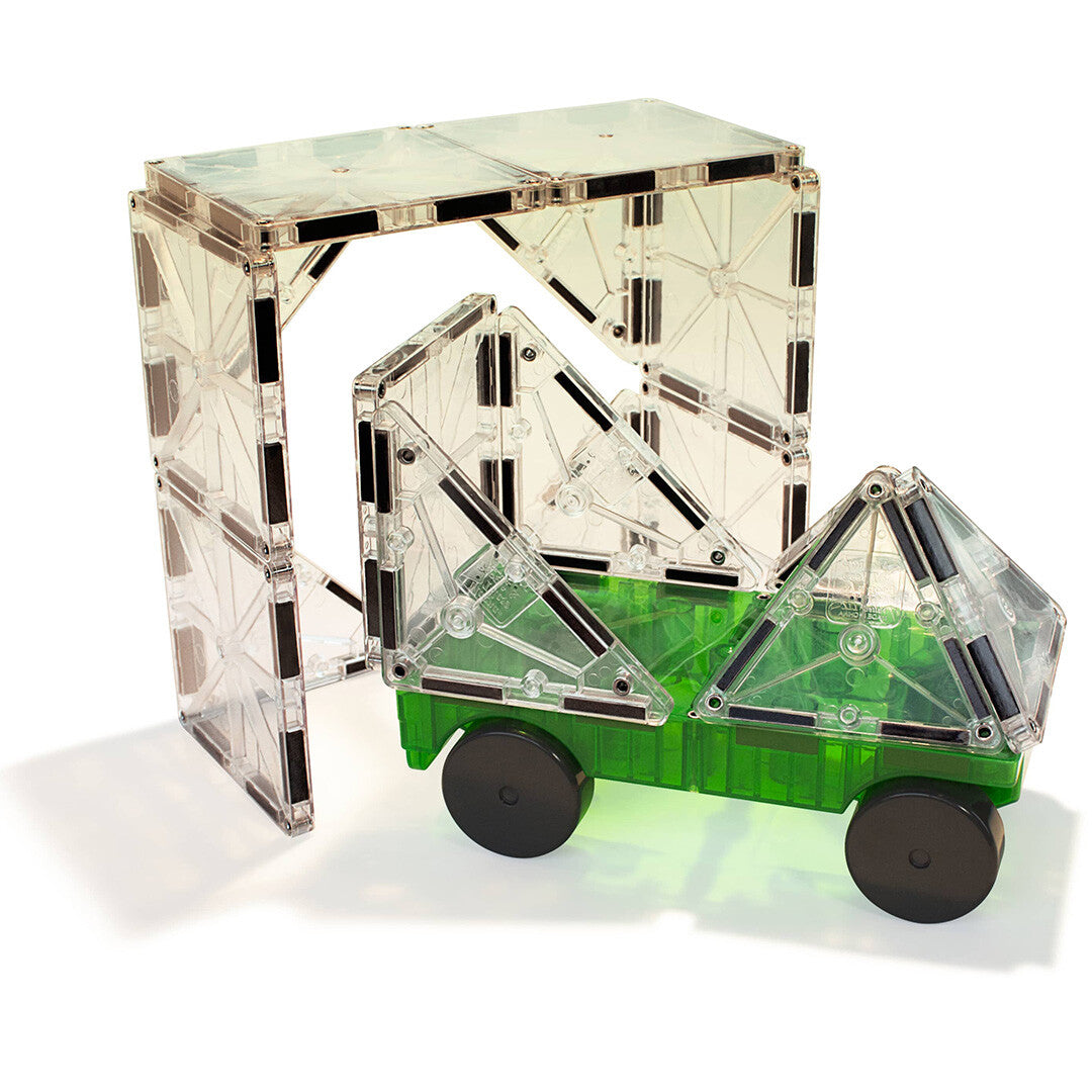 Een groene Magna-Tiles autoplatform met transparante magneetbouwstenen erop, rijdend onder een boog van magneetbouwstenen.