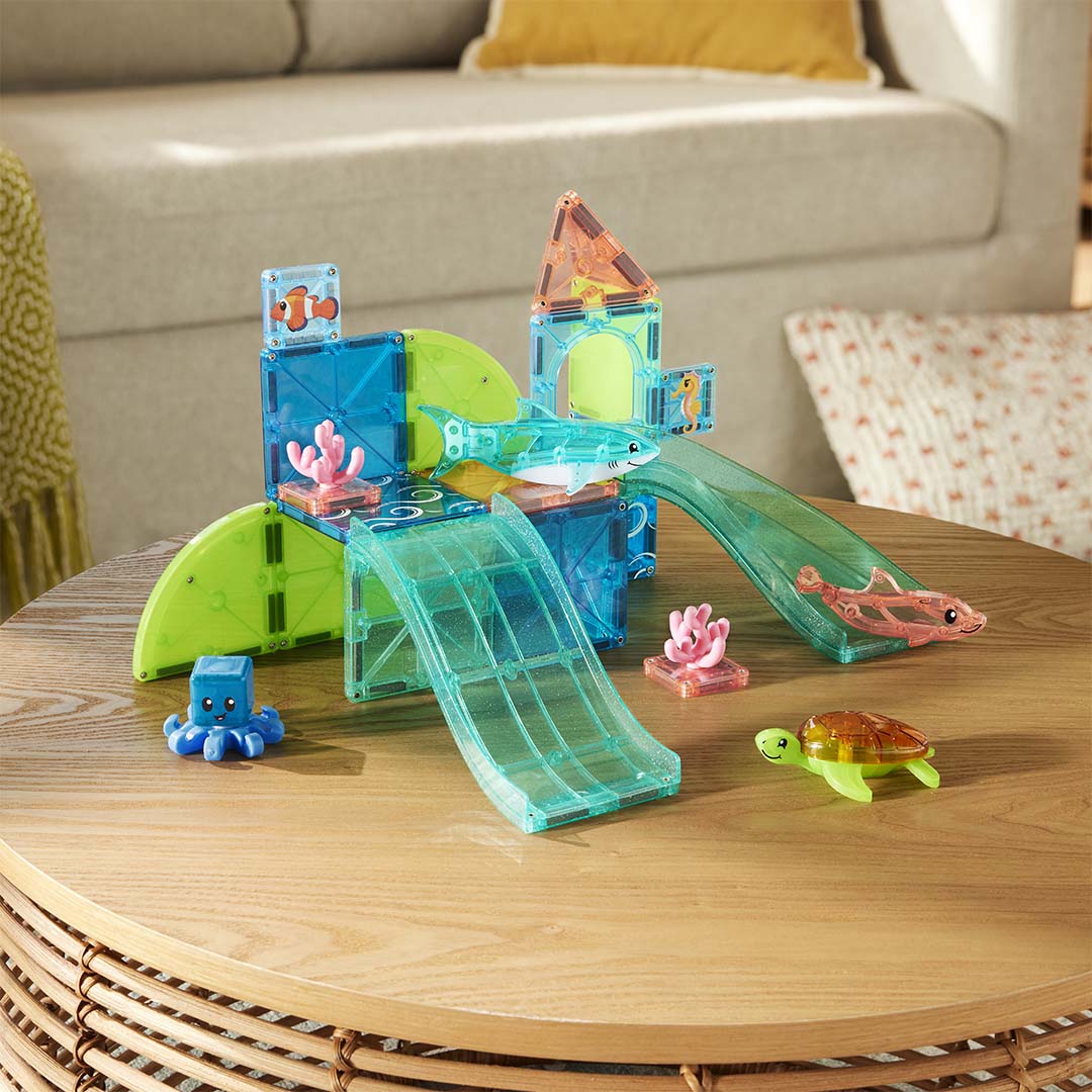 De Magna-Tiles Coral Reef magnetische bouwset met zeedieren staat op een houten salontafel.