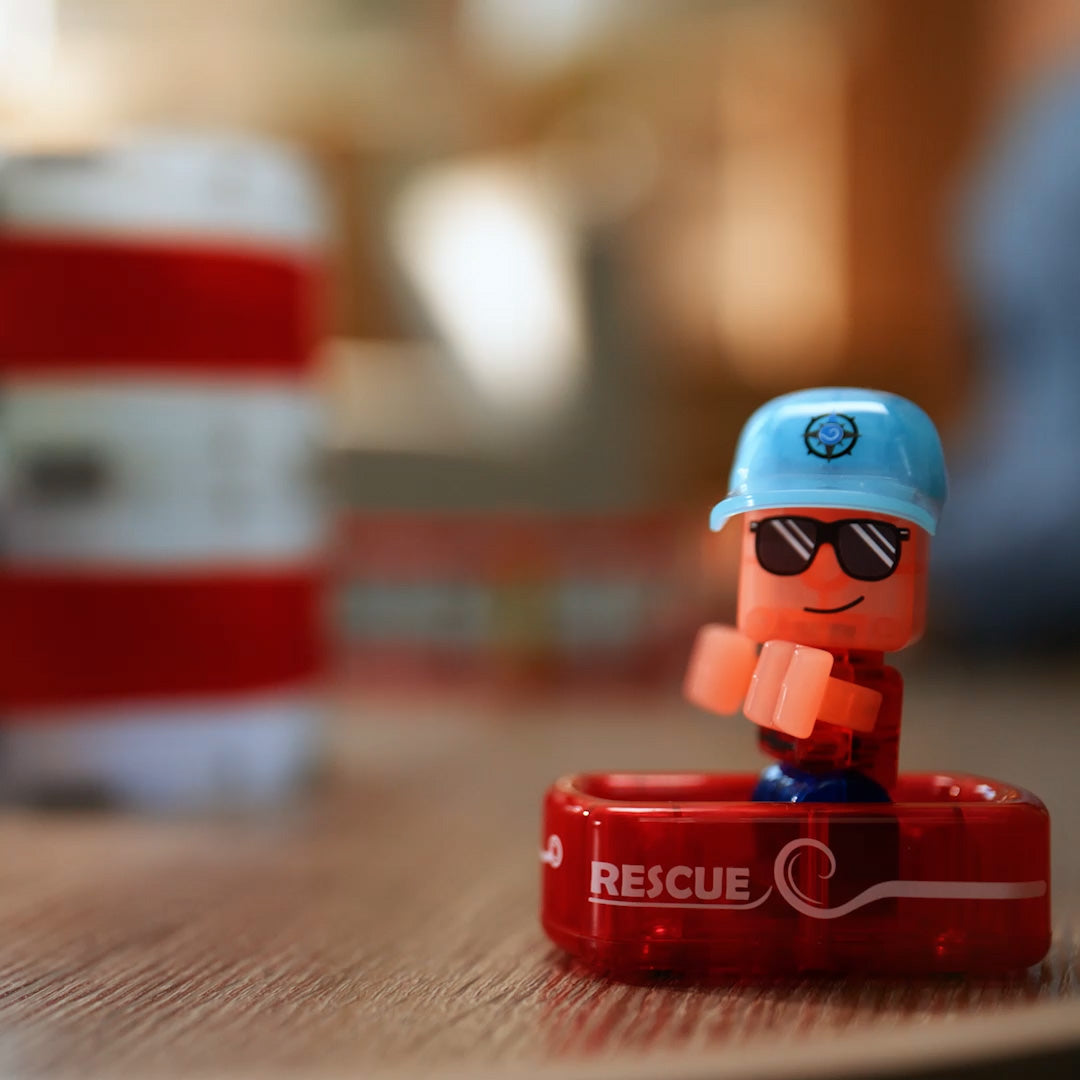 Close-up van een speelfiguur met blauwe pet en zonnebril in een rood reddingsbootje.