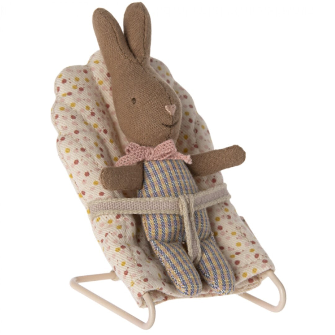 Maileg knuffelkonijn in een miniatuur babywipper met stippenpatroon.