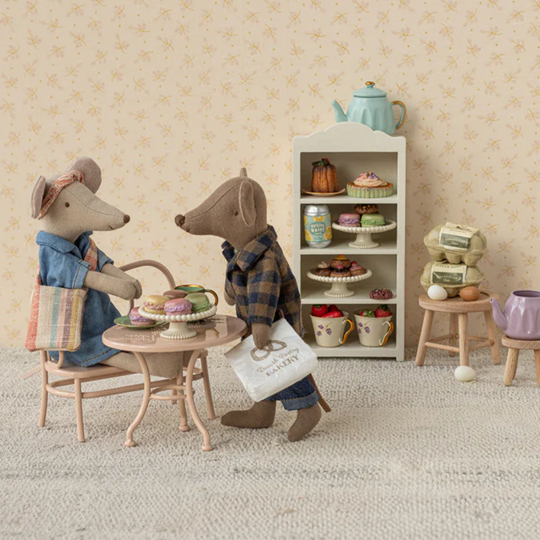 Twee Maileg knuffelmuizen in een miniatuur bakkerij met gebakjes op een plank en tafel.