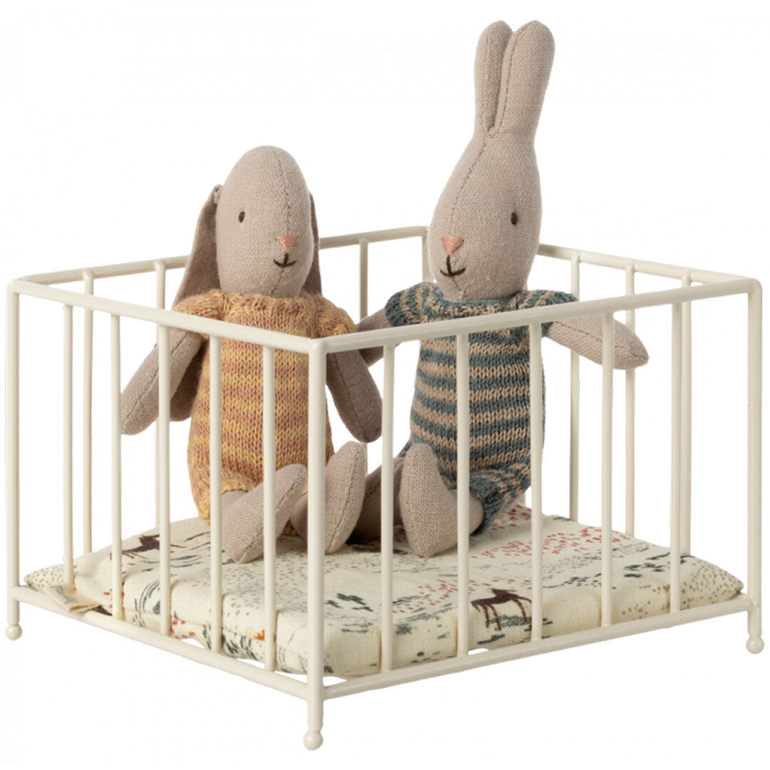 Maileg poppenbabybox met twee konijnenpoppen in gebreide kleding op een matrasje met dierenpatroon.