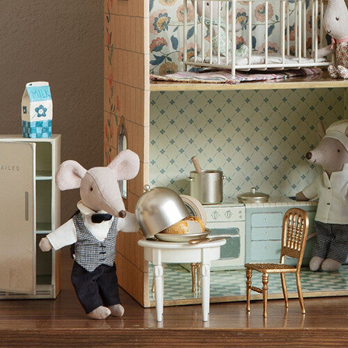 Maileg muis als ober serveert aan de beige poppenhuis bijzettafel in een poppenhuis keuken.