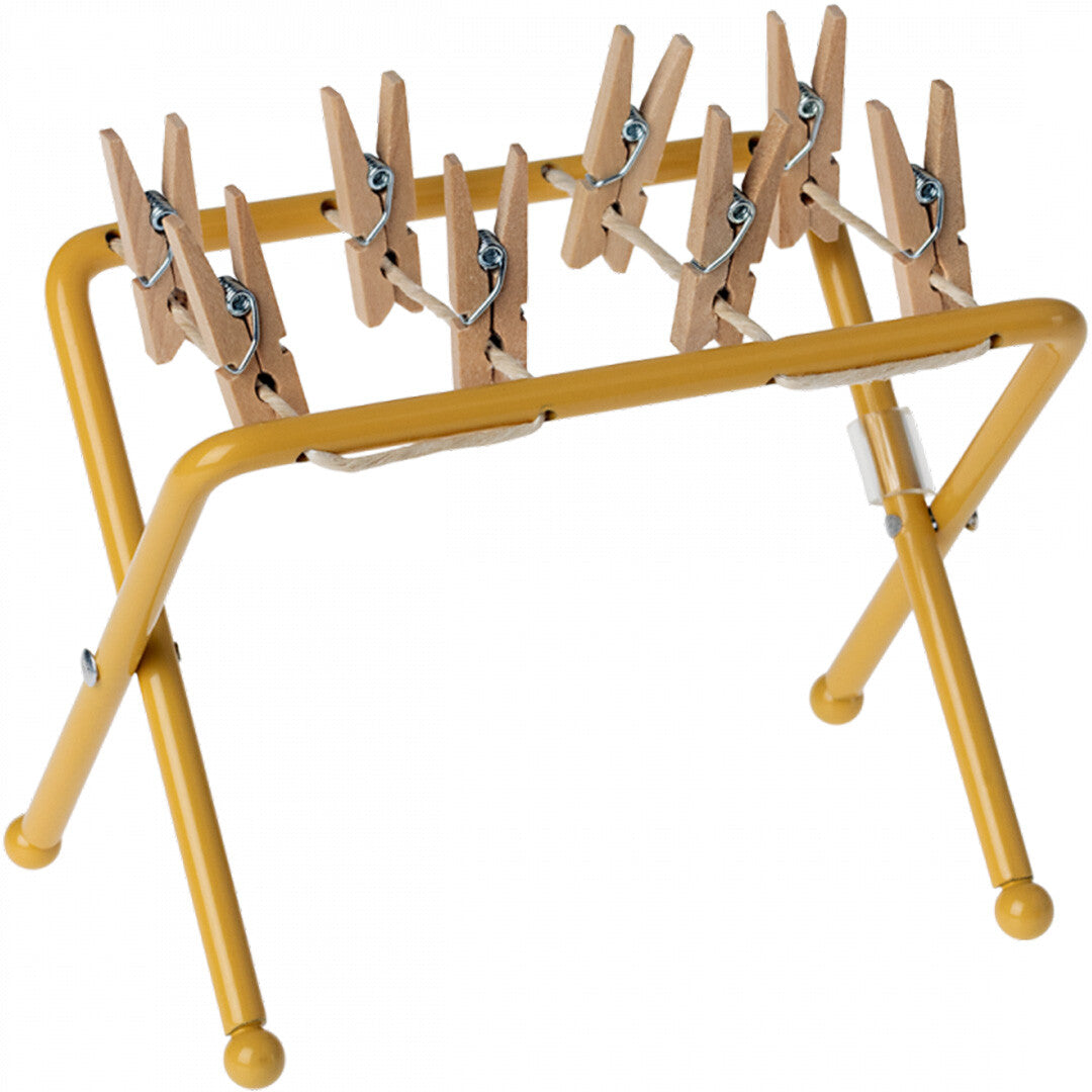 Maileg okergeel metalen droogrek voor poppenhuis met houten knijpertjes.
