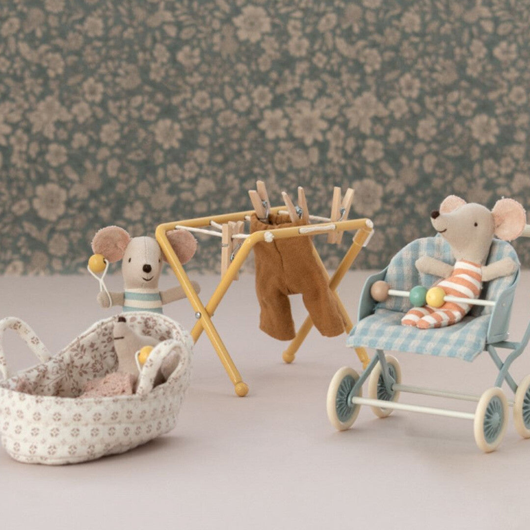 Maileg poppenhuis droogrek met een muispopje dat was ophangt, naast een kinderwagen en een wiegje.