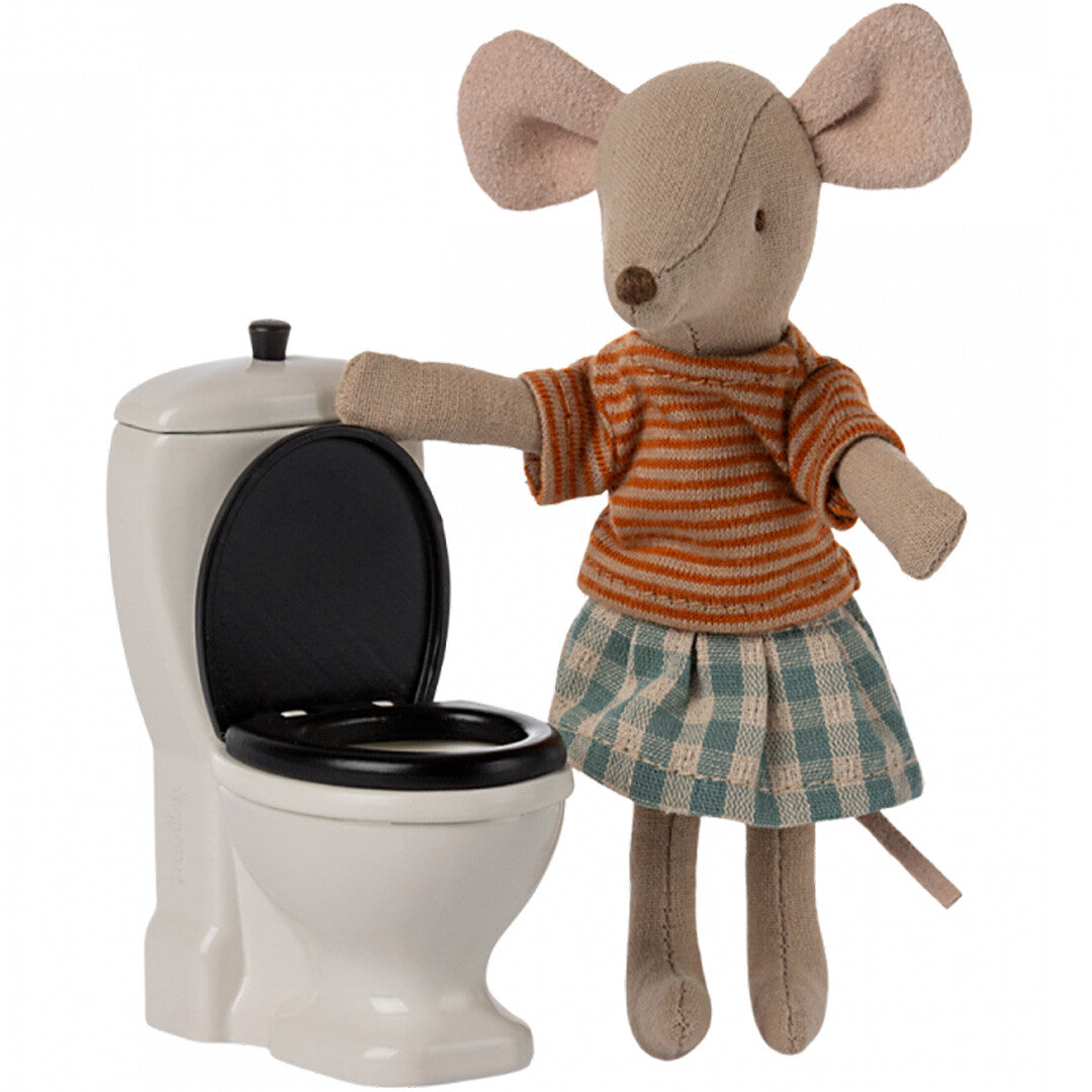 Maileg muispop in gestreepte trui en geruite rok staat naast het open poppenhuis toilet.