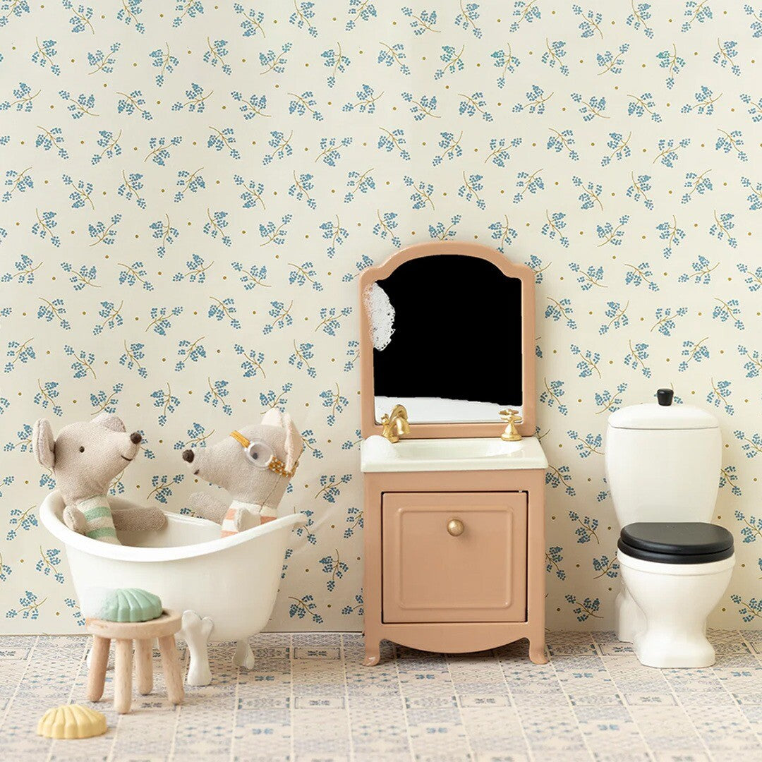 Een complete poppenhuis badkamer met bad, wastafel en toilet, met twee muizen in bad.