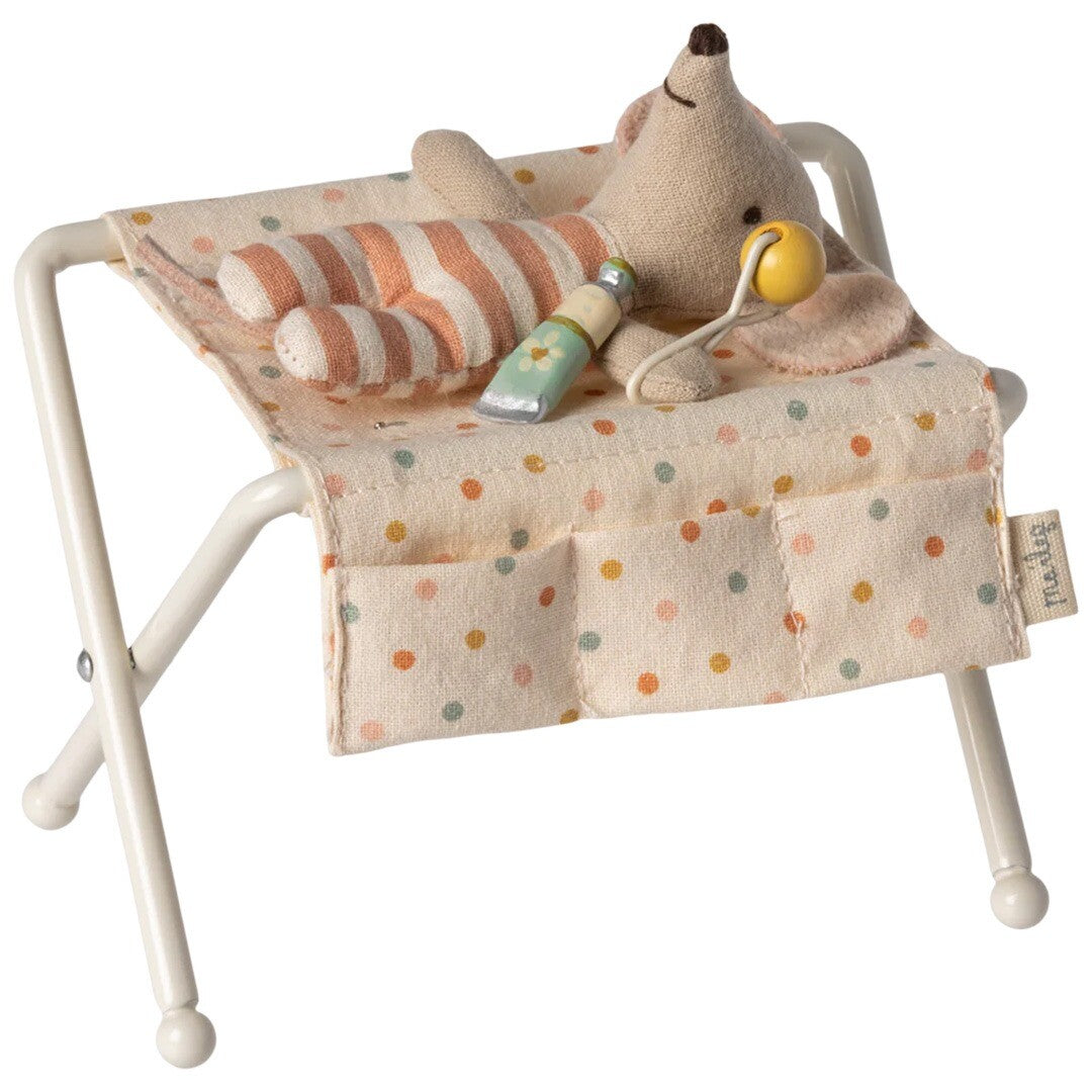 Maileg poppenhuis verzorgingstafel met een babymuisje in gestreepte pyjama.