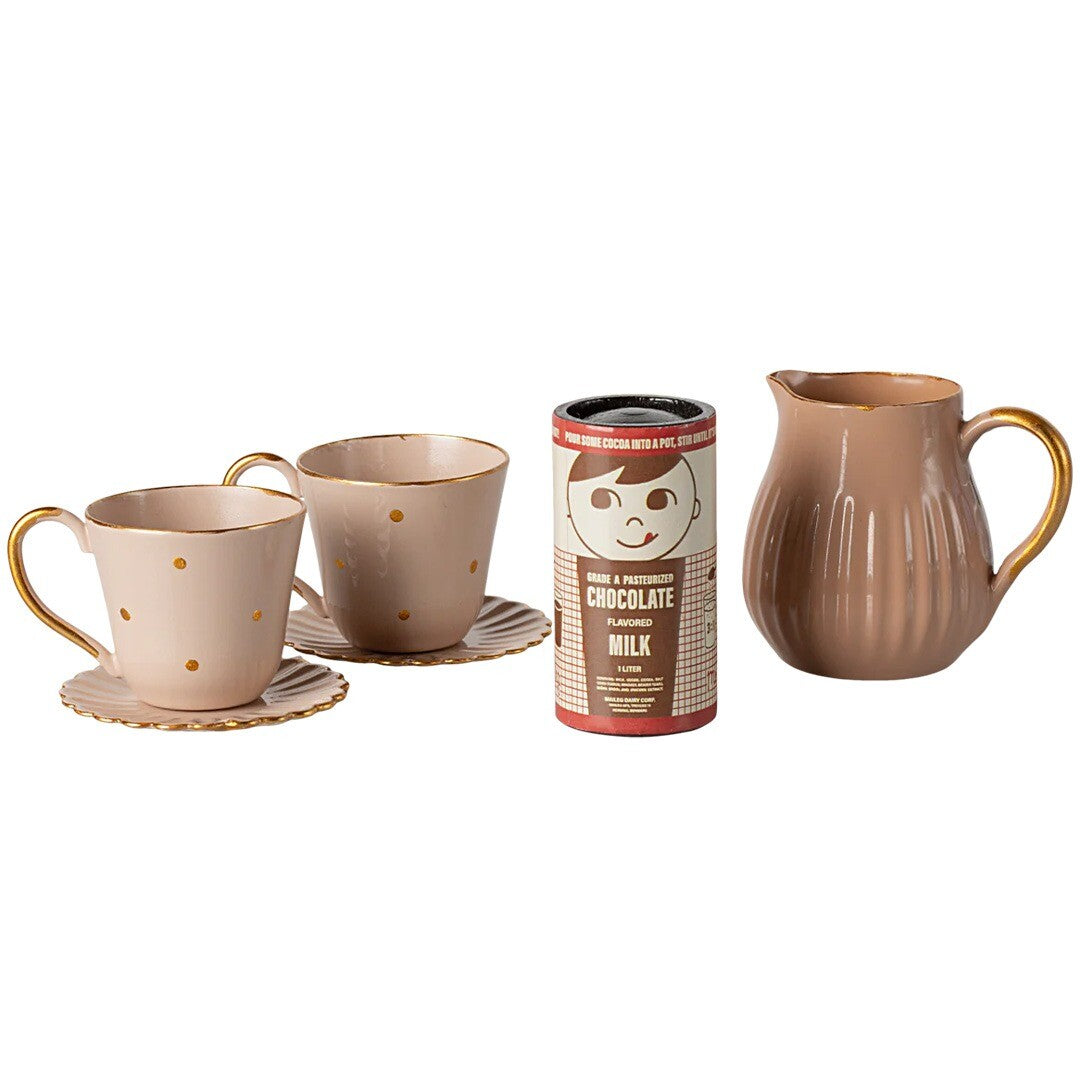 Maileg poppenhuis warme chocolademelk set met twee beige kopjes met gouden stippen, schoteltjes, een melkkan en een pakje chocolademelk.