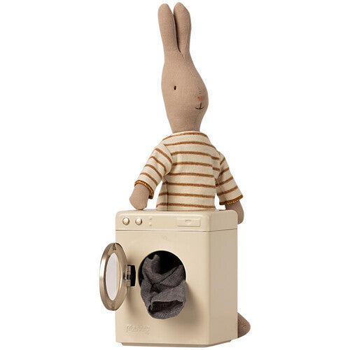 Maileg poppenhuis wasmachine met open deur en een konijn pop in een gestreept shirt erachter.