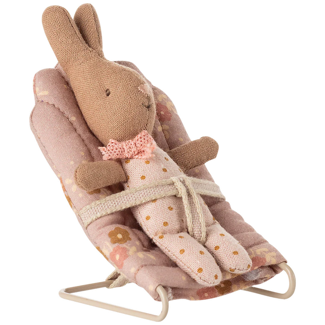 Maileg bruin konijntje met roze stippenpakje zit in het roze gebloemde poppenhuis wipstoeltje.
