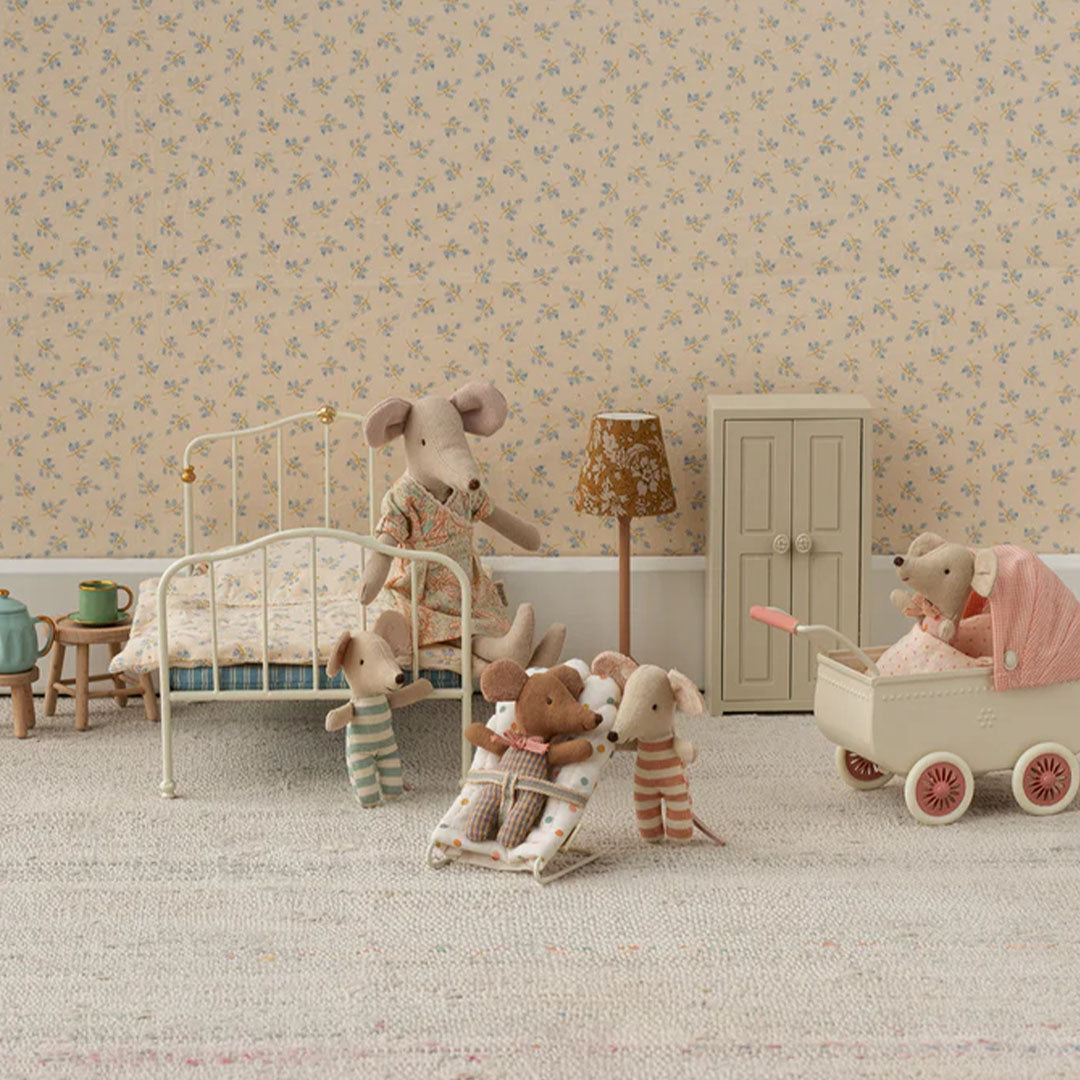 Maileg poppenkinderwagen met een muis erin, staand in een speelgoedkamer met andere Maileg muizen en meubels.