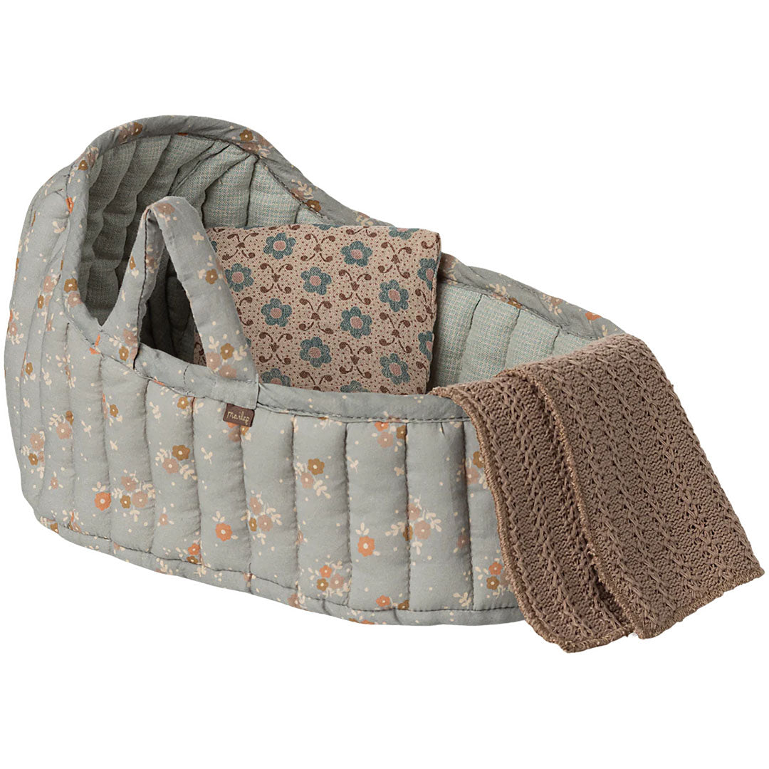 Maileg poppenreiswieg met blauw gebloemd patroon, inclusief kussen en bruine gebreide deken.