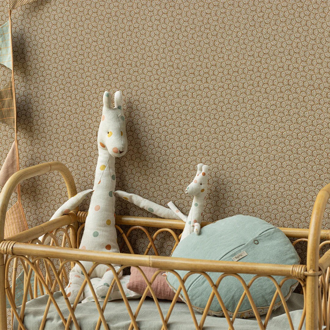 Twee Maileg pluchen safari friends giraffes in een rotan babybedje.