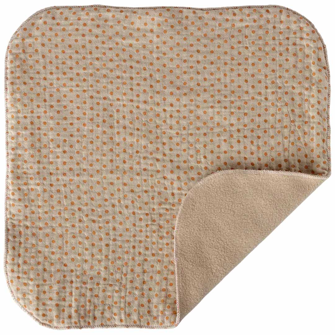 Detail van de beige knuffeldoek met oranje stippen en de zachte effen onderkant.