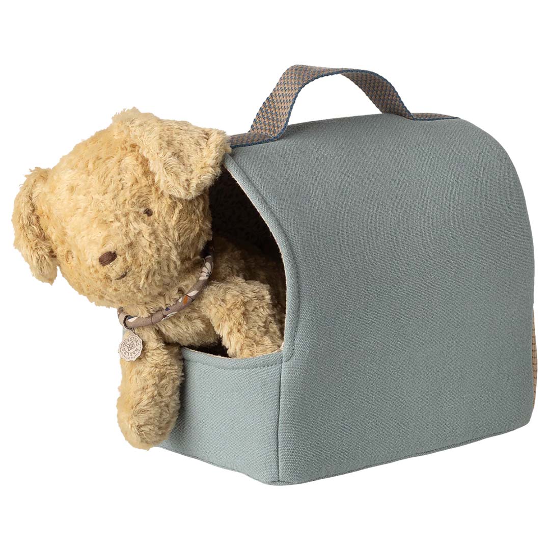 De Maileg knuffel puppy kijkt uit een blauwgrijze stoffen draagtas.