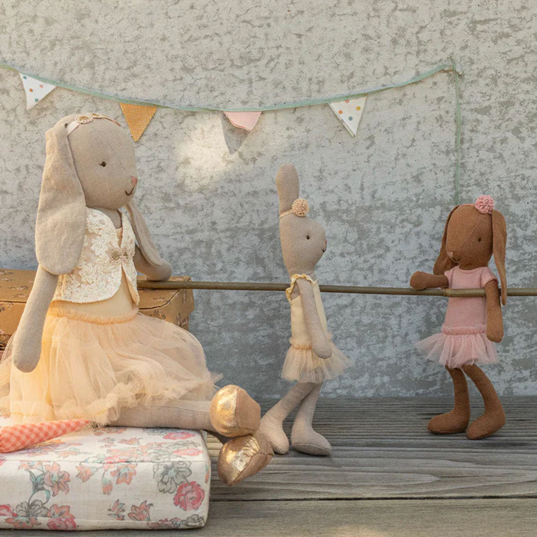 Drie Maileg knuffelkonijnen in ballerina-outfits oefenen aan een balletbarre.