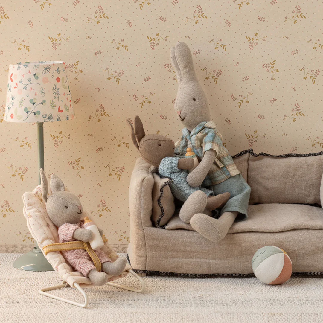 Maileg speelset met een konijnenfamilie, waarbij een konijn een babykonijn vasthoudt en een ander babykonijn in een wipstoeltje zit.