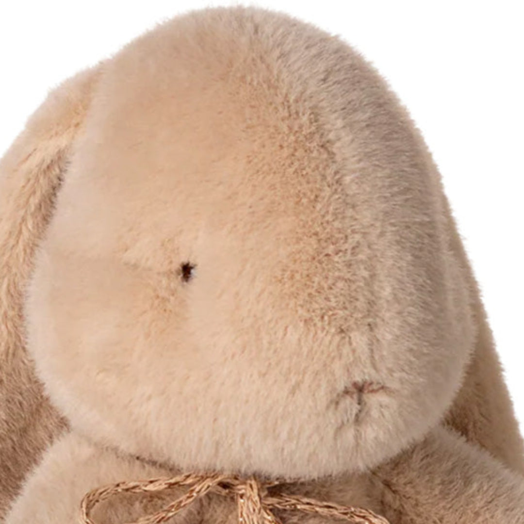 Detail van de kop van het beige pluchen knuffelkonijn.