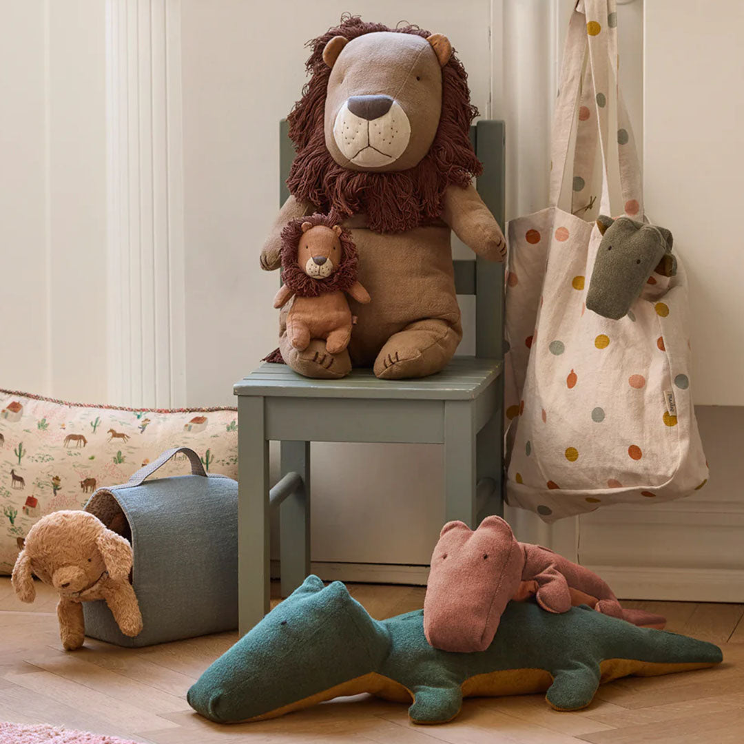 Een collectie Maileg pluchen safari dieren, waaronder leeuwen en krokodillen, in een kinderkamer setting.
