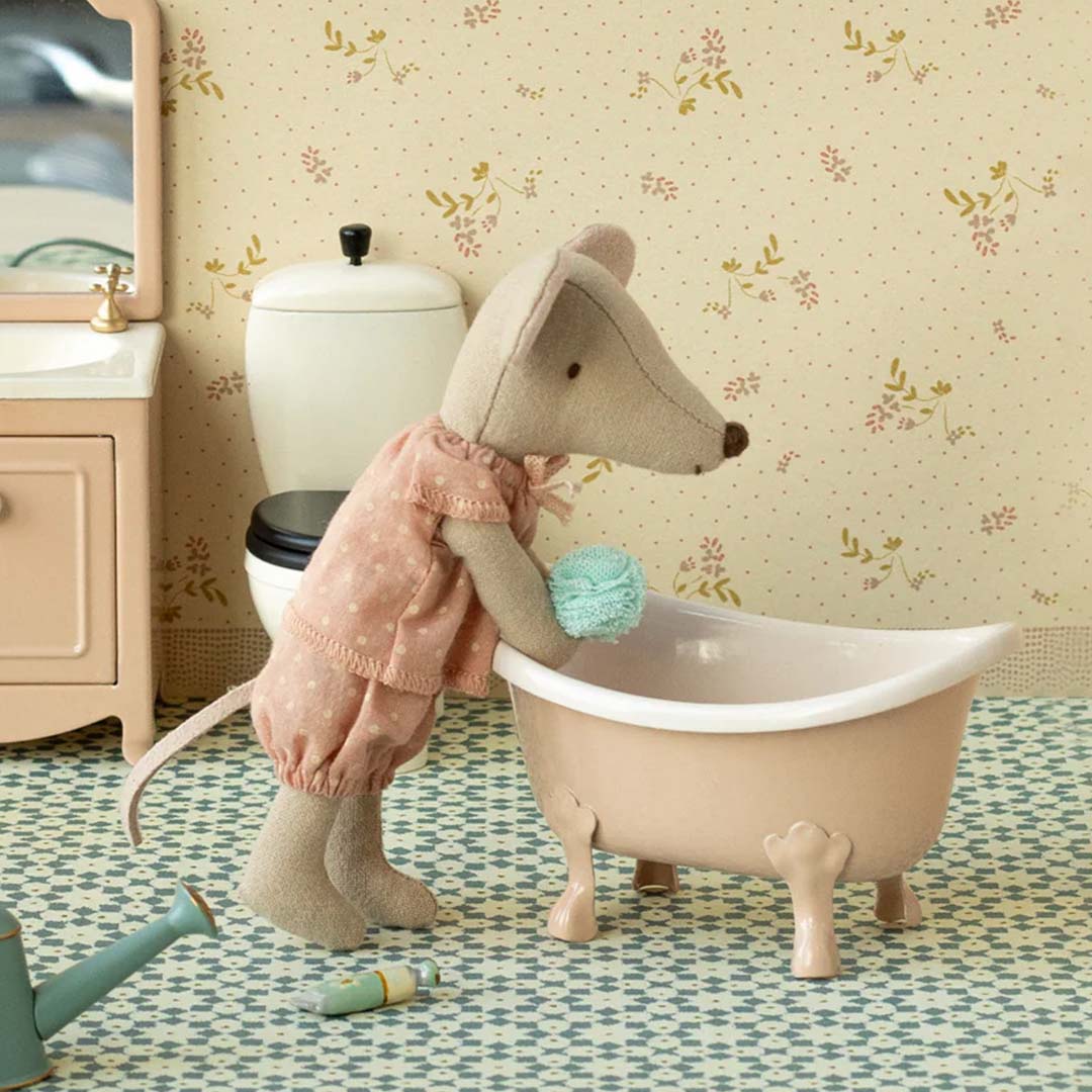 Maileg knuffelmuis grote zus in roze pyjama wast zich met een blauwe spons in een miniatuur roze badkuip.