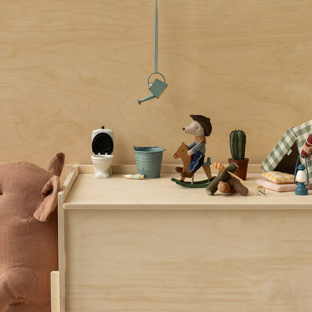 Maileg pluchen cowboy knuffelmuis op een hobbelpaard in een speelset met miniatuurmeubels en accessoires.