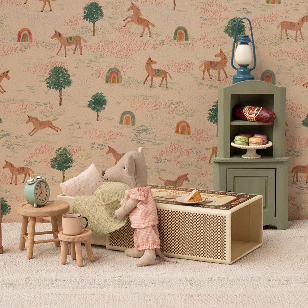 Maileg knuffelmuis in luciferdoosje bed in een miniatuurkamer met meubels en een paardenbehang.