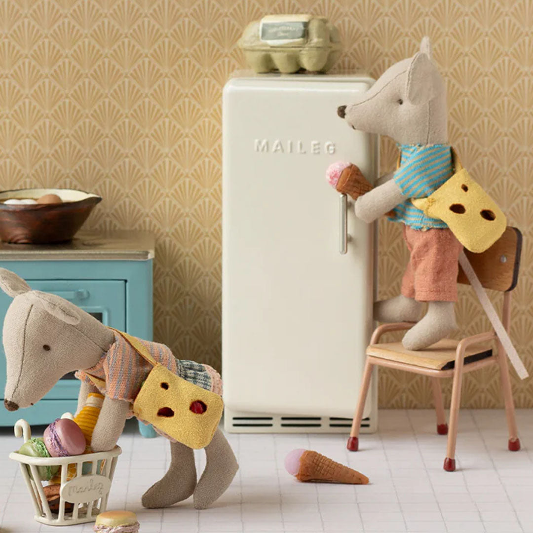 Twee Maileg knuffelmuizen in een miniatuurkeuken, één bij de koelkast en één bij een boodschappenmandje.