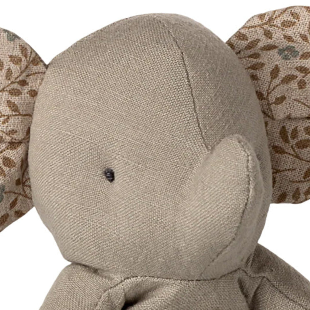 Detailopname van de kop van de Maileg pluchen olifant met oren met bladerpatroon.