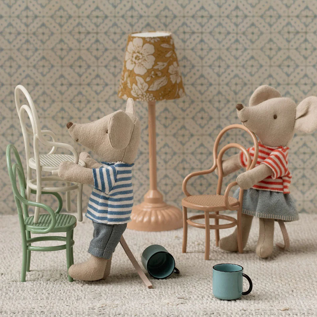 Twee Maileg muizenpoppen met poppenhuisstoelen, een lamp en kopjes in een kamer.