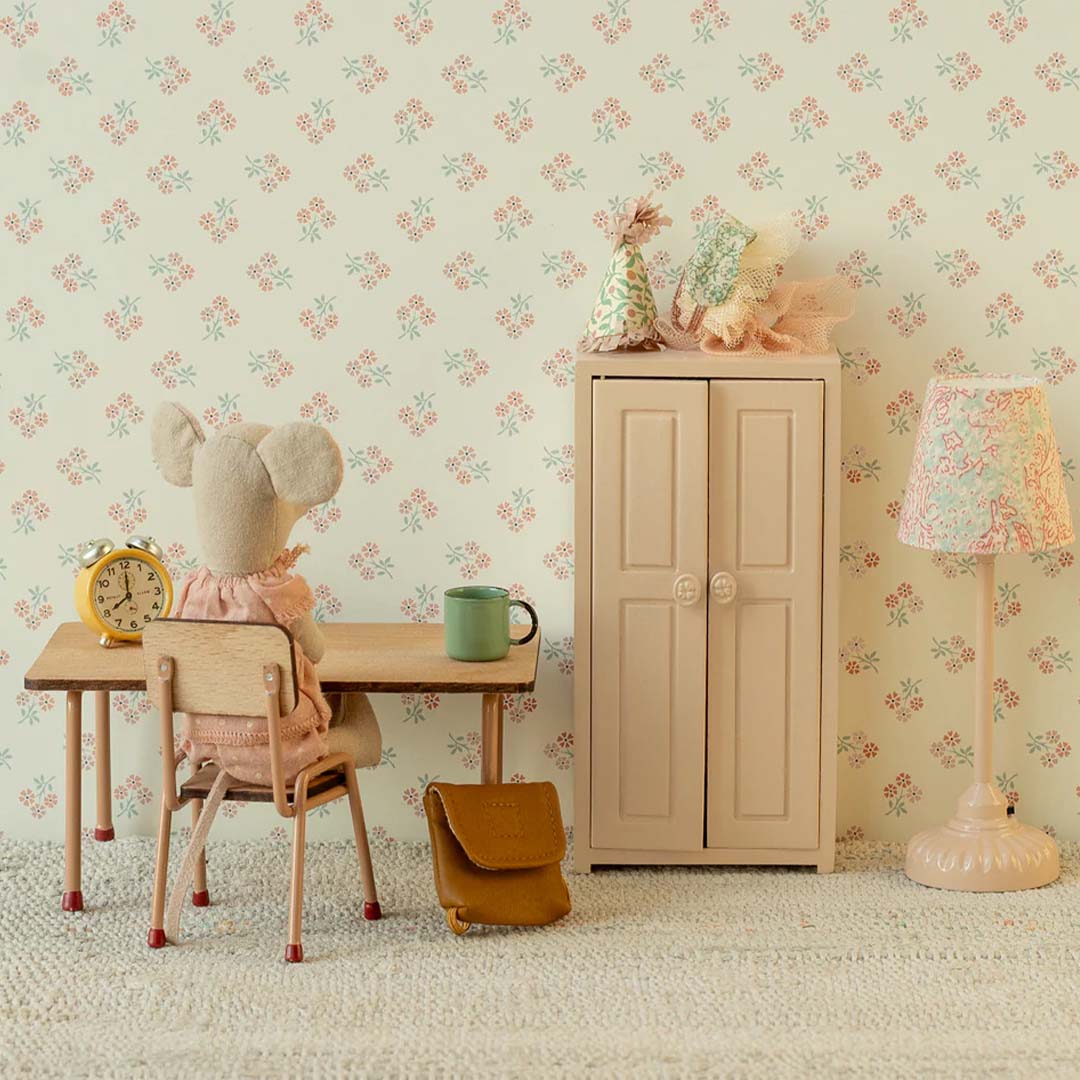 Maileg poppenhuis scène met een muis aan een bureau naast de lichtroze kledingkast en een lamp.