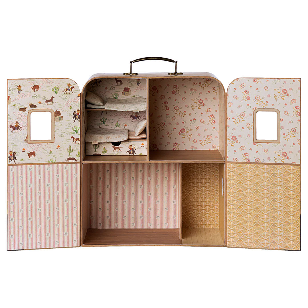 Maileg poppenhuis koffer opengeklapt met lege kamers en een bed met dekens.