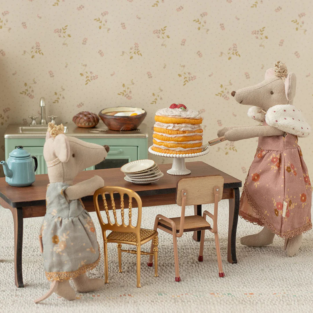 Twee Maileg muizen in een poppenhuis keuken, waarvan één de taart serveert.
