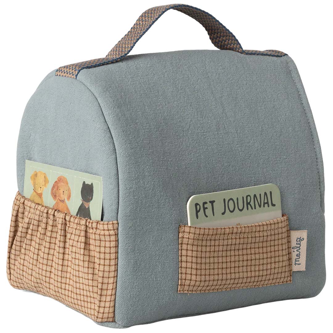 Achterkant van de Maileg poppenreistas voor huisdier met twee zakjes, gevuld met een pet journal en dierenkaartjes.