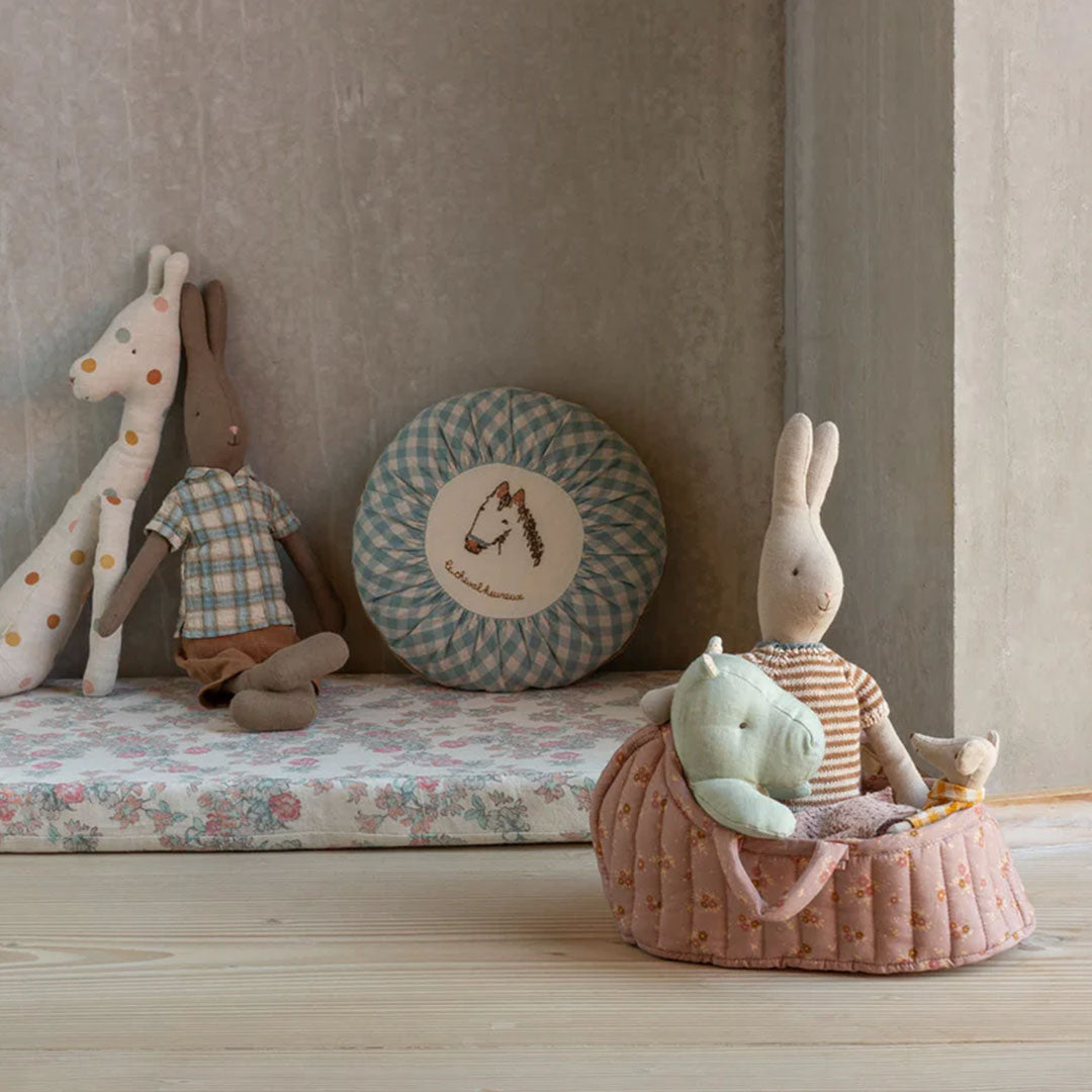 Maileg poppenreiswieg met knuffels in een speelkamer setting.