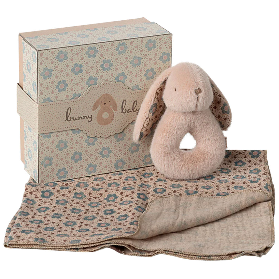 Maileg giftbox met een roze pluche konijnenrammelaar en een gebloemd babydekentje.