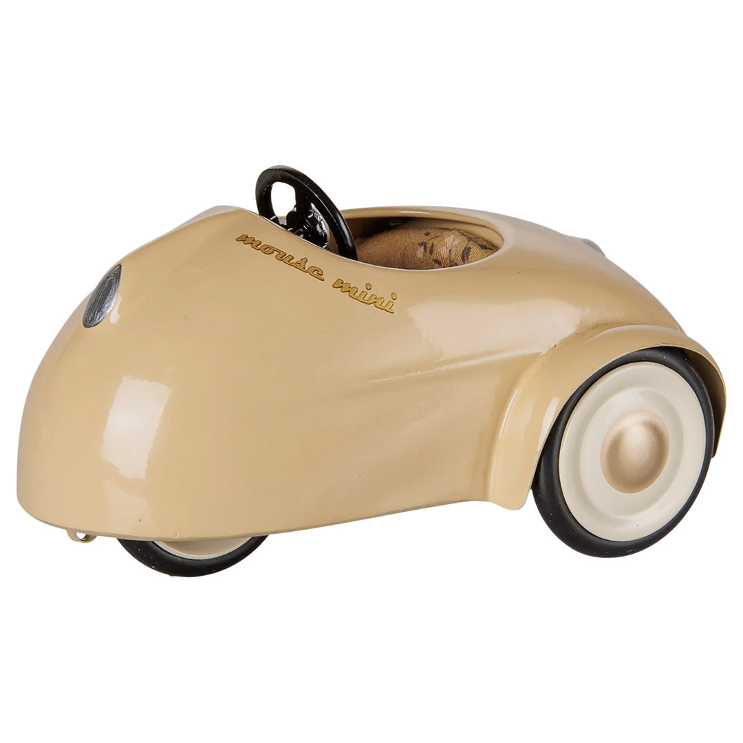 Maileg beige speelauto met 'mouse mini' op de zijkant, schuin van achteren gefotografeerd.