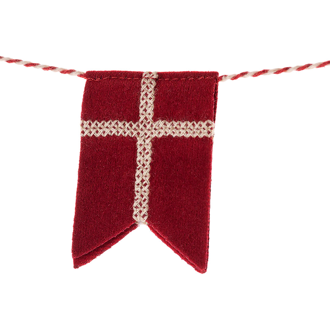 Detail van een rood stoffen vlaggetje met wit kruis van de slinger.